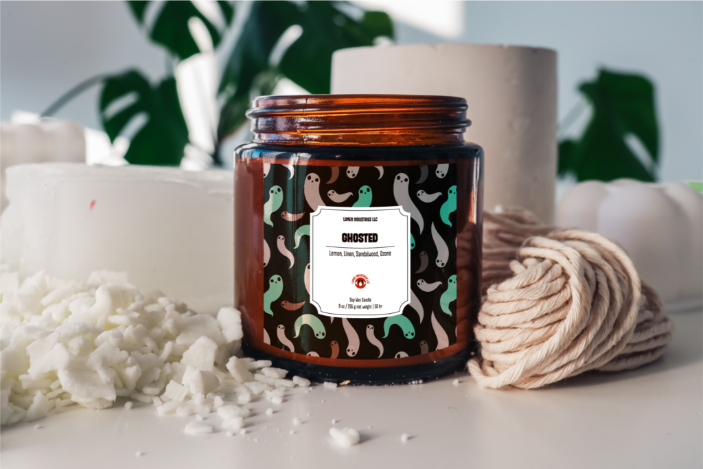 Cozy Autumn Candles, ghosted candle label with dark background and green and gray ghost pattern mock-up on an amber candle container.